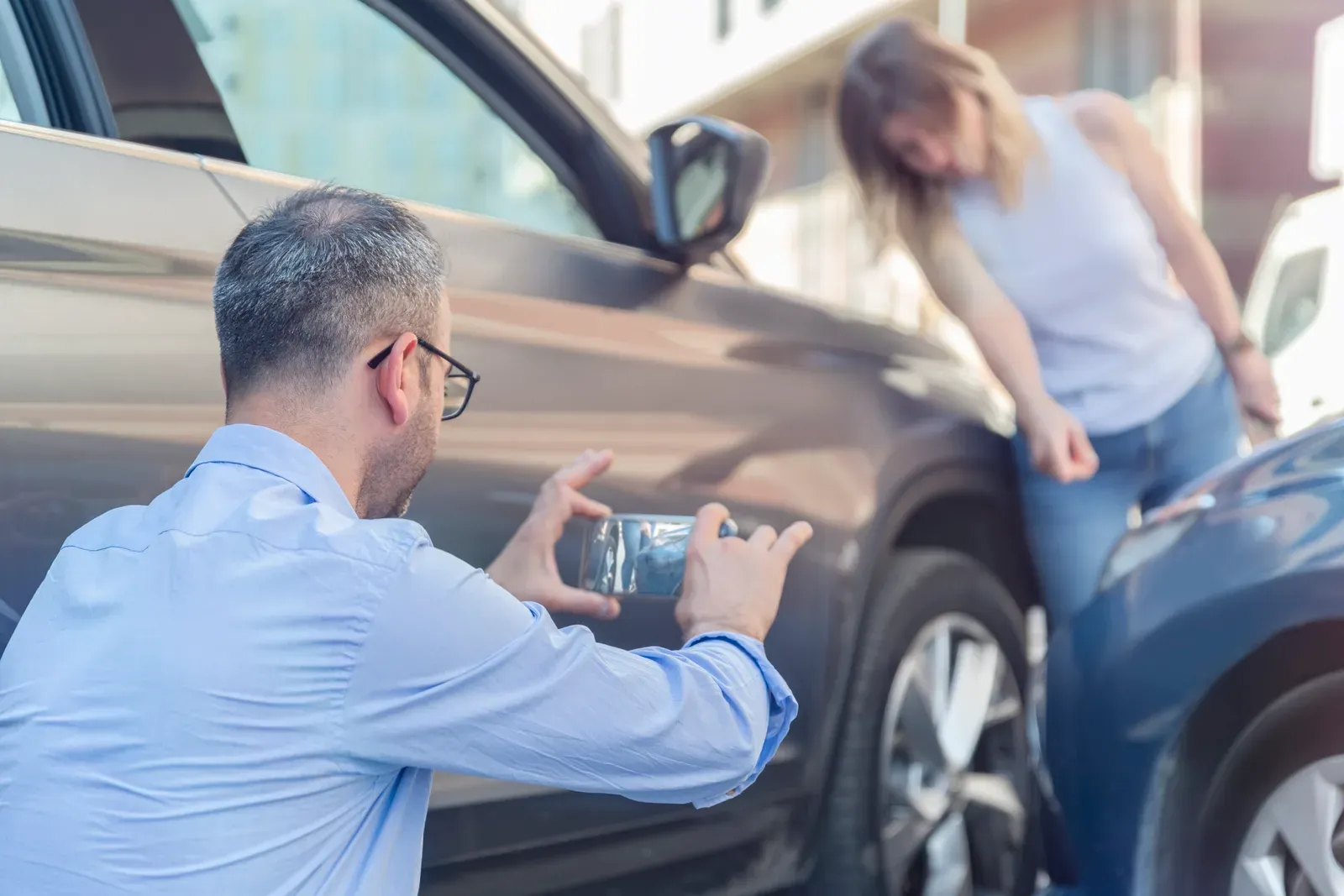 Driver photographing damage after an accident