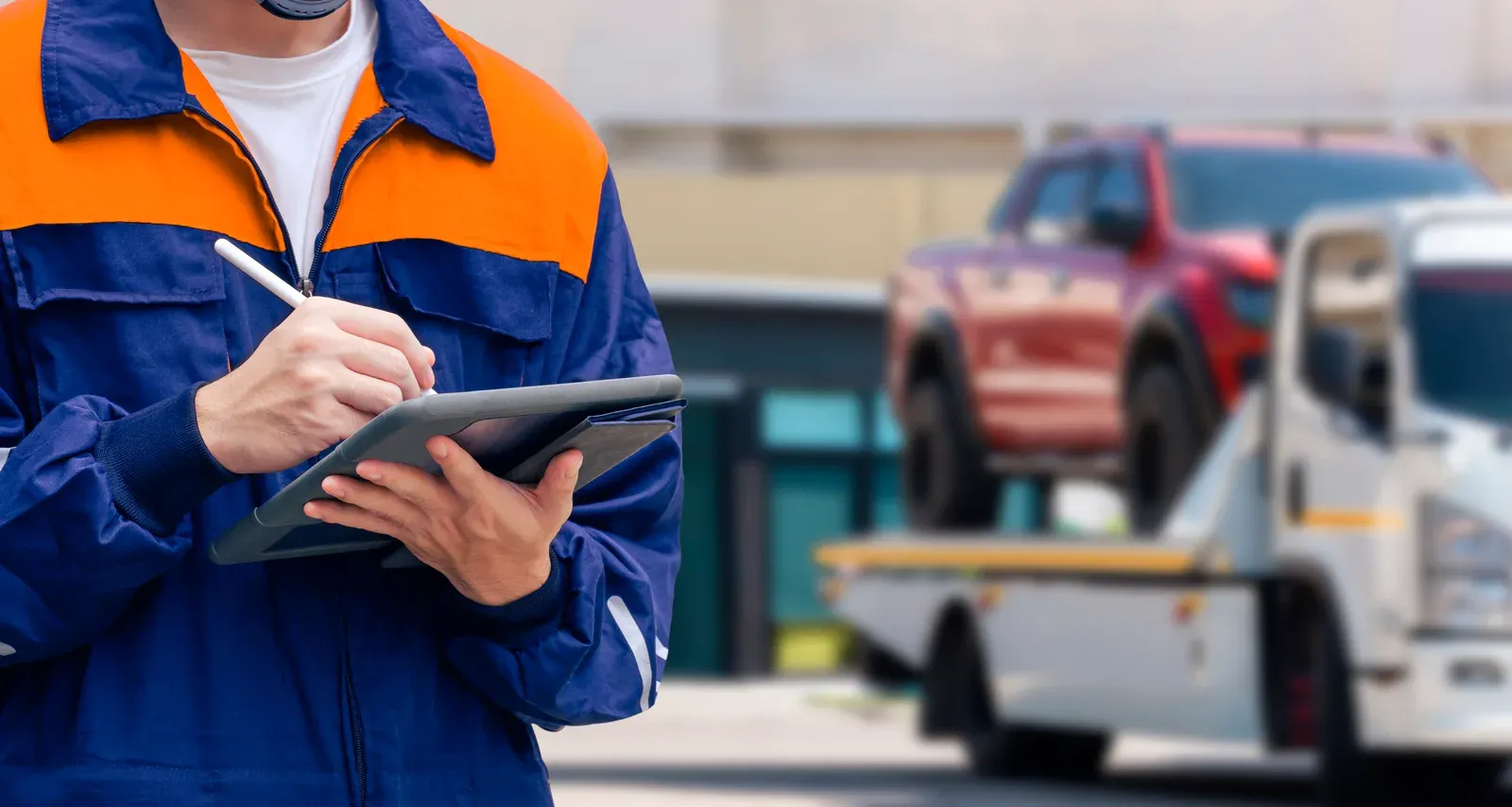 Insurance adjuster documenting vehicle damage on a tablet
